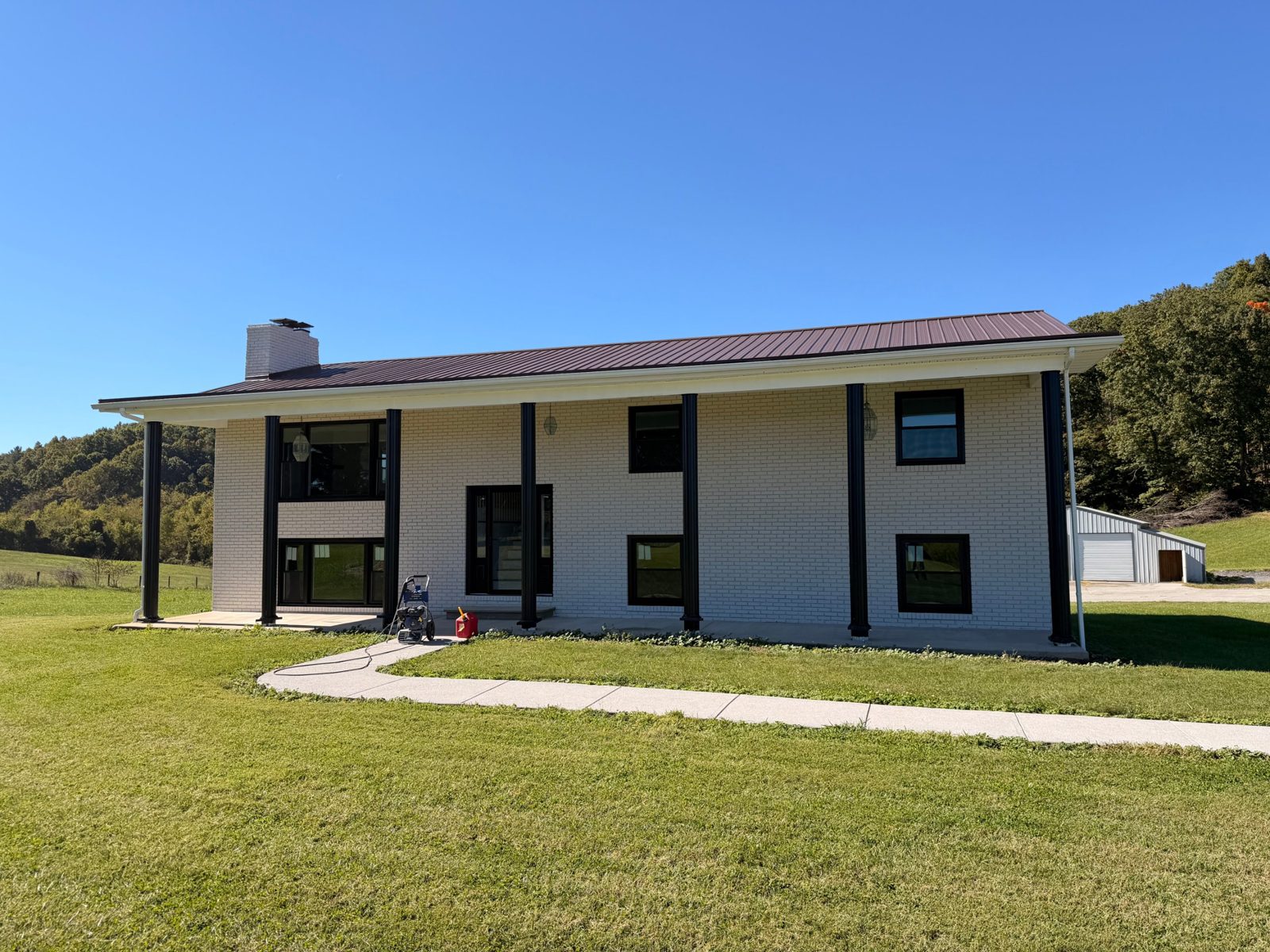 Painted brick split-foyer home with new metal roof and covered front porch